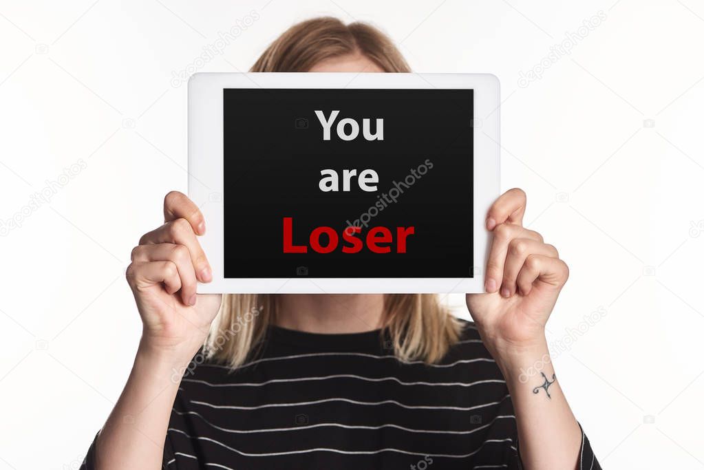 victim of cyberbullying showing digital tablet with you are loser lettering on screen isolated on white