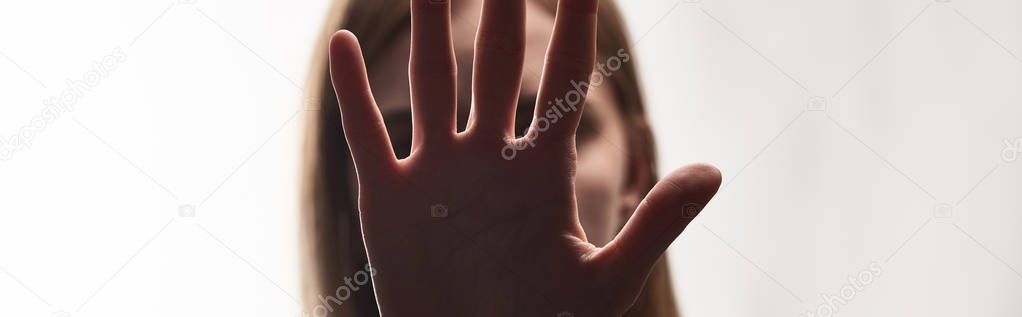panoramic shot of victim of bullying showing stop sign isolated on white