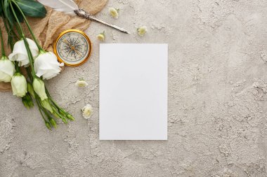boş kart, altın pusula ve gri dokulu yüzeyüzerinde beyaz eustoma çiçekler yakın bej çuval bezi üzerinde quill kalem üst görünümü