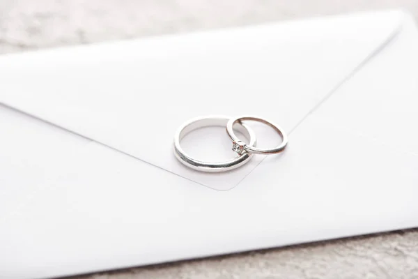 Silver Wedding Rings White Envelope Grey Textured Surface — Stock Photo, Image