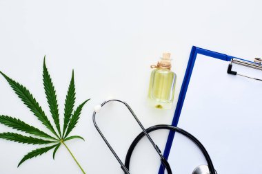 şişe, stetoskop ve beyaz arka plan üzerinde pano Cbd yağı yakınında tıbbi kenevir yaprağı üst görünümü