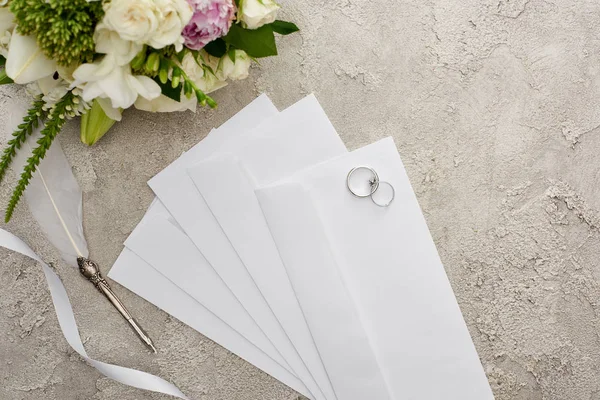 Vista Superior Anéis Casamento Envelopes Perto Caneta Pena Fita Branca — Fotografia de Stock