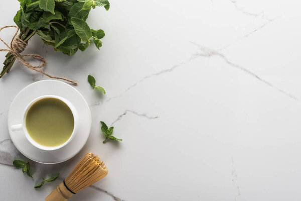 top view of traditional matcha tea with mint on white table