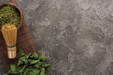koyu taş masada bambu mat üzerinde geleneksel matcha çay ve nane üst görünümü