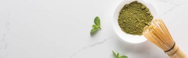 beyaz masada matcha çay tozu ve nane üst görünümü