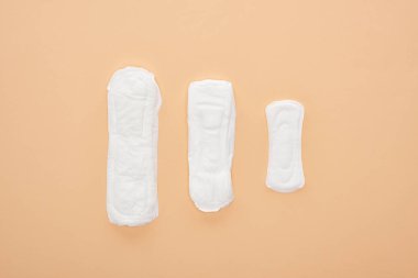 top view of three white cotton sanitary towels isolated on beige clipart