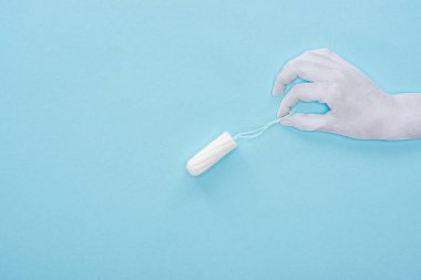 mavi arka plan üzerinde beyaz kağıt el ve pamuk tampon üst görünümü