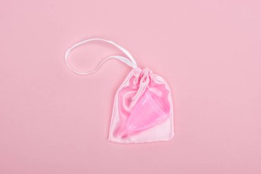 pembe arka plan üzerinde çanta pembe plastik adet fincan üst görünümü