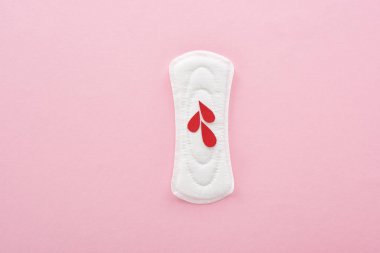 pembe arka plan üzerinde kan damlaları ile beyaz sıhhi peçete üst görünümü