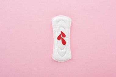 top view of white sanitary napkin with blood drops on pink background clipart