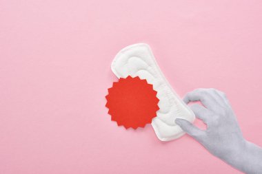 pembe arka plan üzerinde kan işareti ile beyaz sıhhi peçete tutan el kırpılmış görünümü