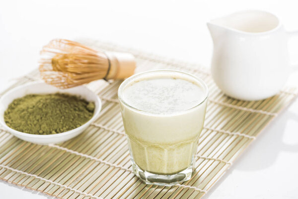 green matcha tea with milk on bamboo mat