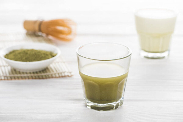 selective focus of traditional green matcha tea on white table 