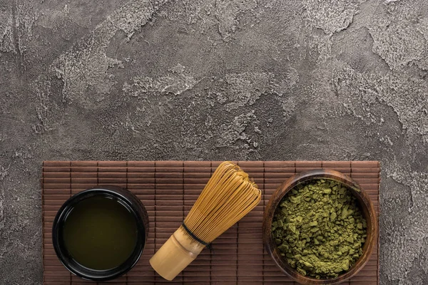 在深色石桌上的竹垫上 有胡须的绿色火柴茶的顶视图 — 图库照片