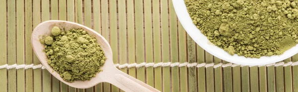 碗和木勺的顶视图与竹垫上的绿色火柴茶粉 — 图库照片