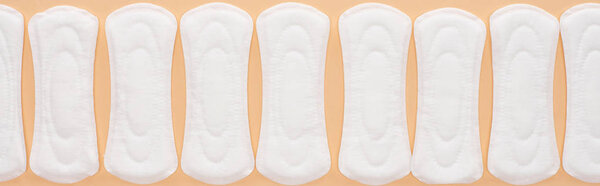 flat lay with white cotton sanitary towels isolated on beige, panoramic shot