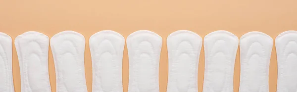 ベージュに隔離された白い綿の衛生タオルの列 パノラマショット — ストック写真