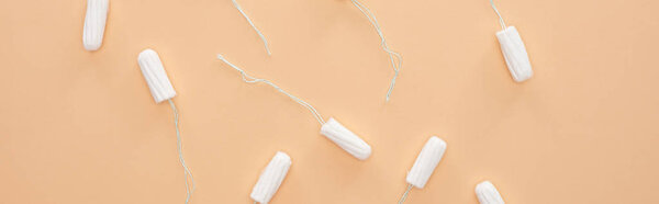 top view of white cotton tampons scattered isolated on beige, panoramic shot