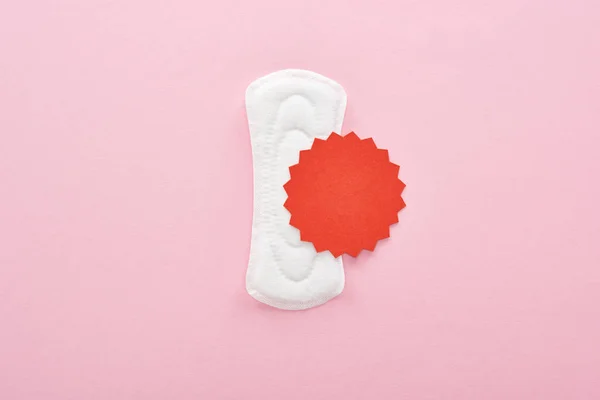 白色卫生巾的顶视图 粉红色背景上带有血牌 — 图库照片