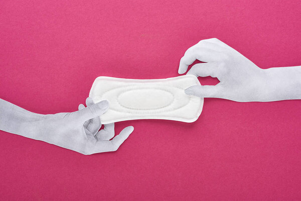top view of paper cut hands and white sanitary napkin on purple background