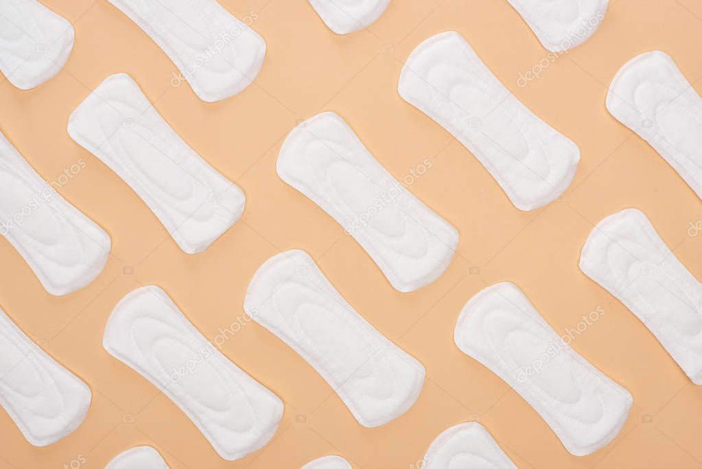 seamless pattern with white cotton sanitary towels isolated on beige