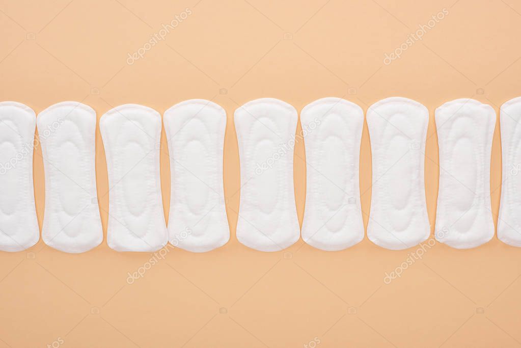 flat lay with white cotton sanitary towels isolated on beige
