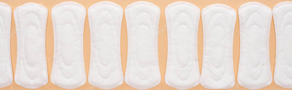 flat lay with white cotton sanitary towels isolated on beige, panoramic shot