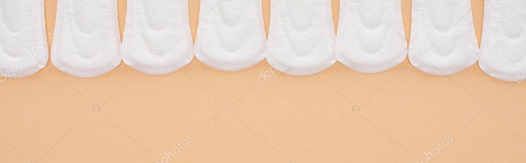 flat lay with white cotton sanitary napkins isolated on beige, panoramic shot