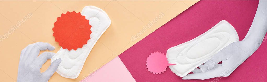 panoramic shot of white hands with sanitary towels and cards on pink, purple and beige background