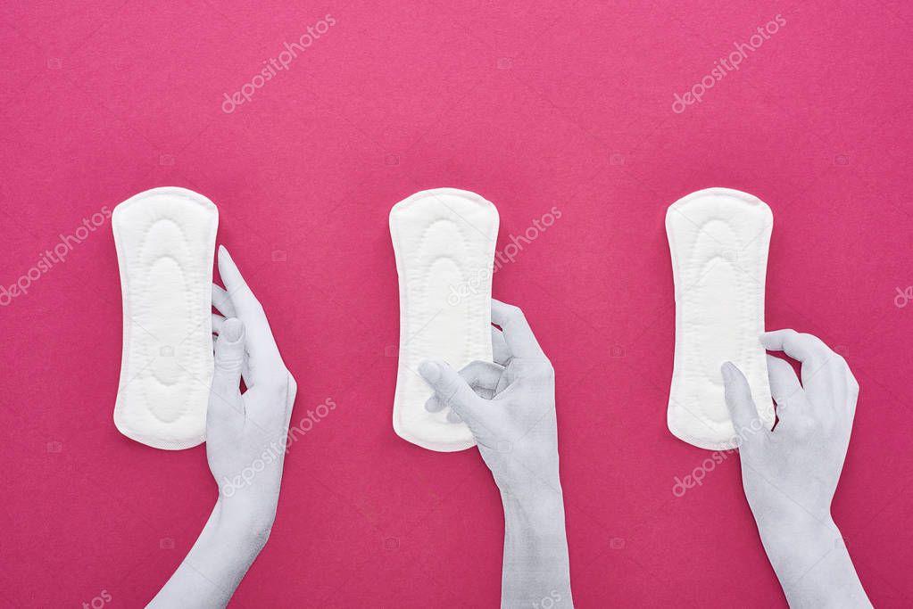 top view of paper cut white hands and white sanitary napkins on purple background