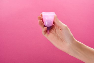 mor arka plan üzerinde kan ile plastik adet fincan tutan kadın kırpılmış görünümü