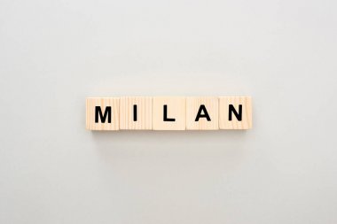 top view of wooden blocks with Milan lettering on white background clipart