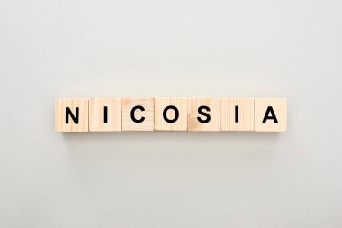 top view of wooden blocks with Nicosia lettering on white background clipart