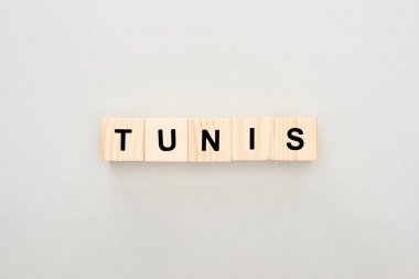 top view of wooden blocks with Tunis lettering on white background clipart