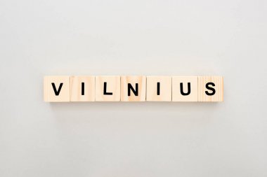 top view of wooden blocks with Vilnius lettering on white background clipart