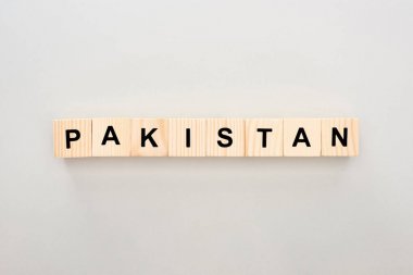 top view of wooden blocks with Pakistan lettering on white background clipart
