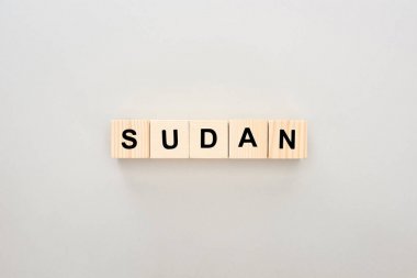 top view of wooden blocks with Sudan lettering on white background clipart