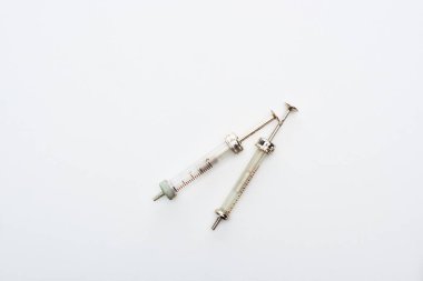 top view of aged syringes on white background with copy space clipart