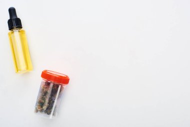 beyaz arka plan üzerinde şişe cbd yağı yakınında plastik kapesrar üst görünümü