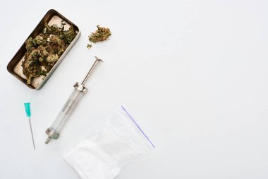 top view of marijuana buds, heroin and syringe on white background clipart