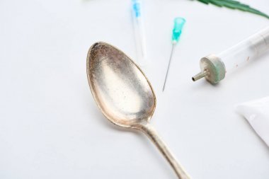 beyaz arka plan üzerinde gümüş kaşık, şırınga ve iğneler yakın görünümü