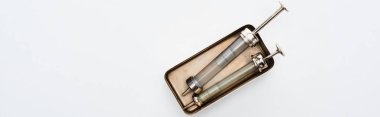 top view of aged syringes in vintage box on white background with copy space, panoramic shot clipart