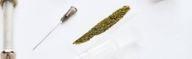 beyaz arka plan üzerinde marihuana ile haddeleme kağıt yakınında şırınga seçici odak, panoramik çekim