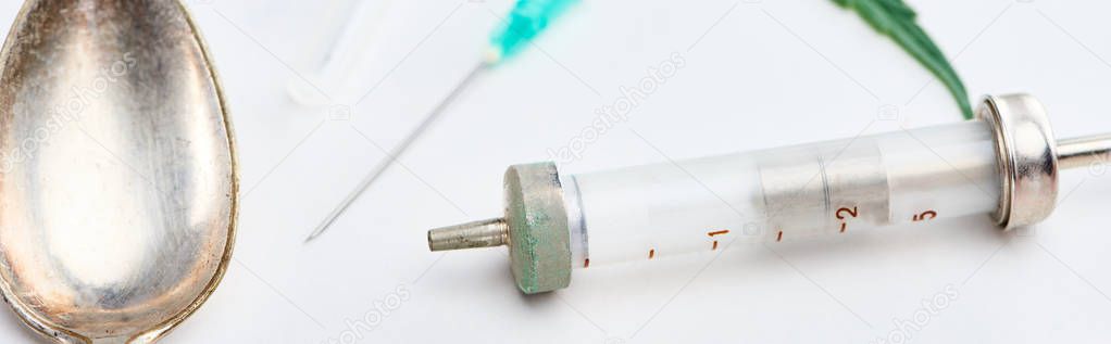close up view of spoon, syringe and needle on white background, panoramic shot