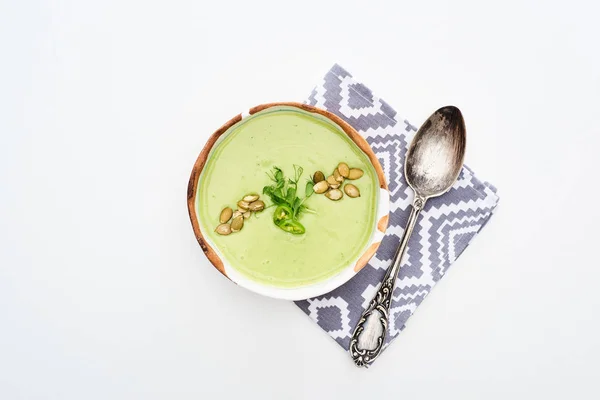 ナプキンに芽とカボチャの種を入れたおいしいクリーミーな緑色の野菜スープのトップビュー — ストック写真