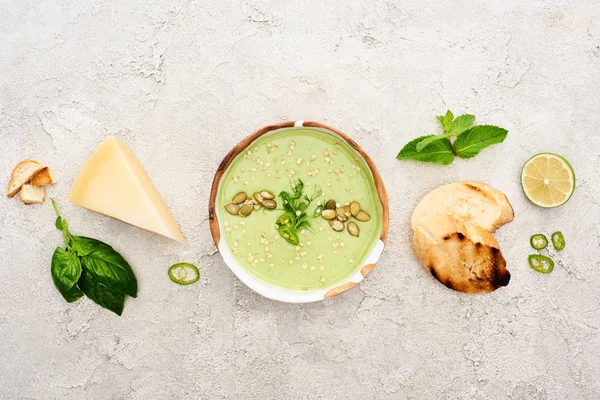 Вид Вкусный Зеленый Сливочный Суп Гренками Сыром Шпинатом Сером Фоне — стоковое фото