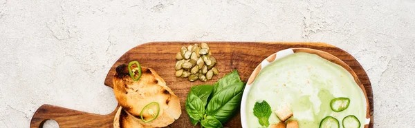 木製のまな板のボウルに緑の野菜クリーミーなスープのパノラマショット — ストック写真