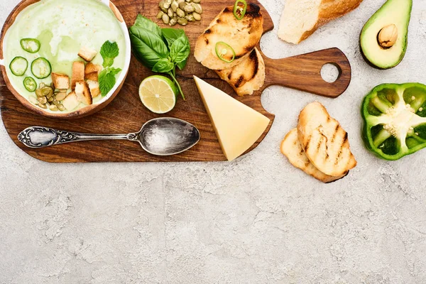 テクスチャ表面の木製のまな板上の緑野菜クリーミーなスープのトップビュー — ストック写真