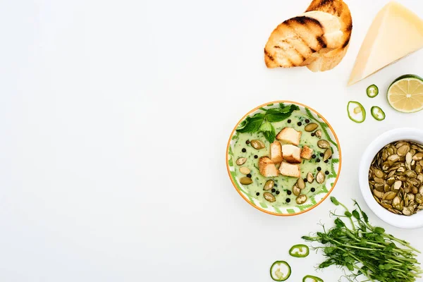 Top view of delicious creamy green vegetable soup served with cheese and croutons isolated on white — Stock Image Top View Delicious Creamy Green Vegetable Soup Served Cheese Croutons Stock Image