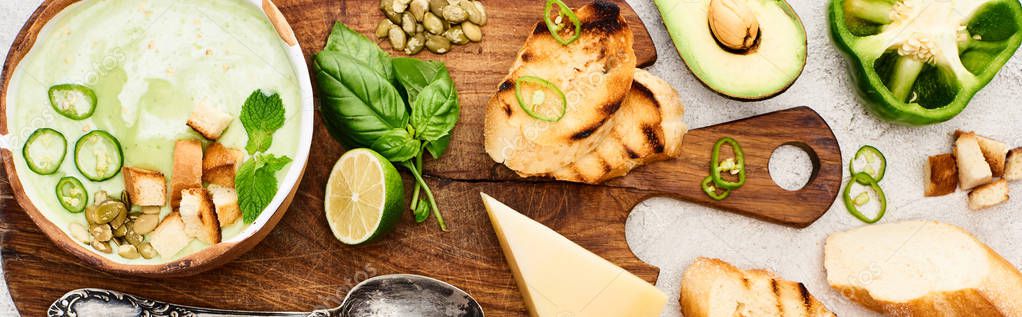 Panoramic shot of green vegetable creamy soup on wooden chopping board with ingredients on textured surface — Stock Image Panoramic Shot Green Vegetable Creamy Soup Wooden Chopping Board Ingredients Royalty Free Stock Images